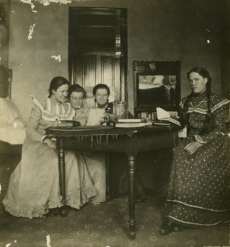 Three students study in their dorm room, most likely in Georgia Burleson Hall, 1890s