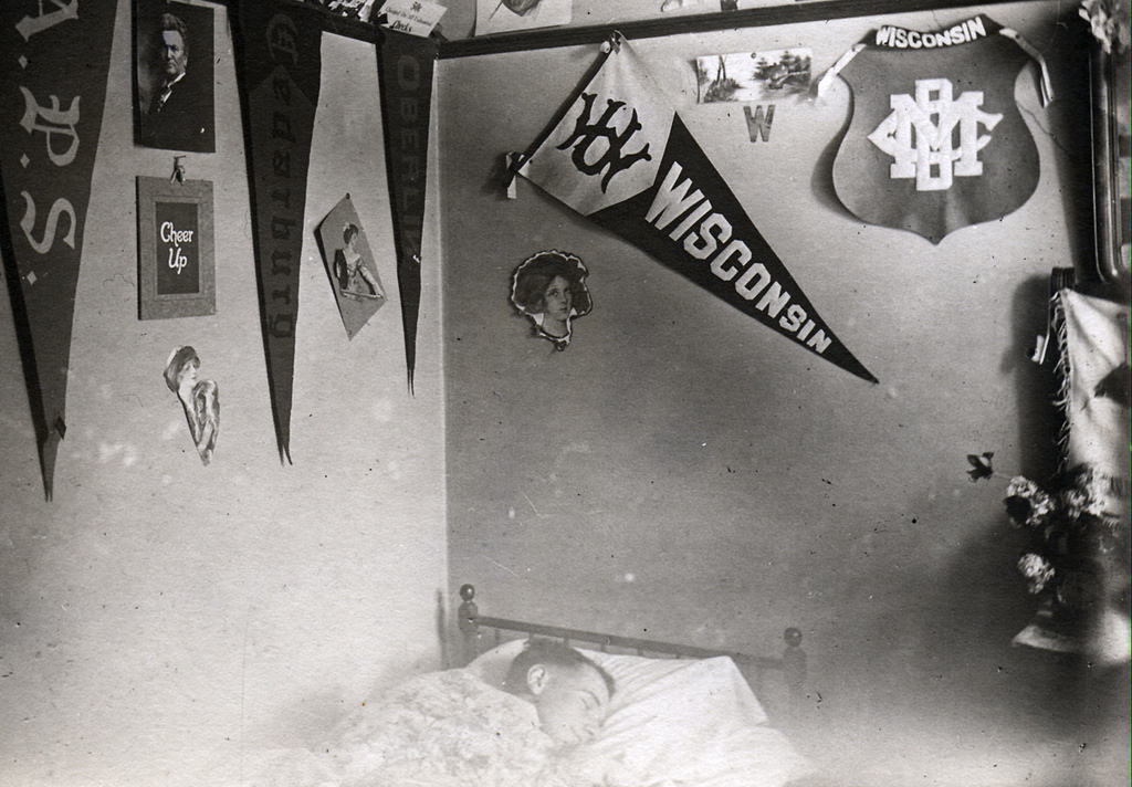Young student sleeping in a men’s boarding house or fraternity house room, 1912.