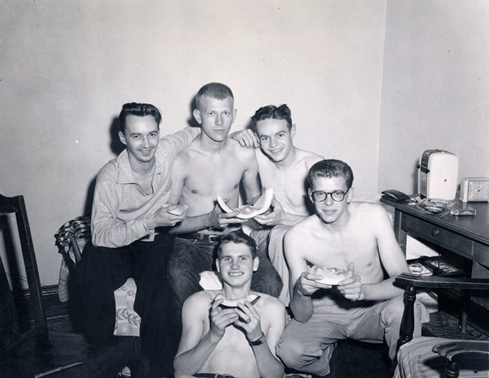 Just a bunch of guys hanging out, eating melon, 1950s.