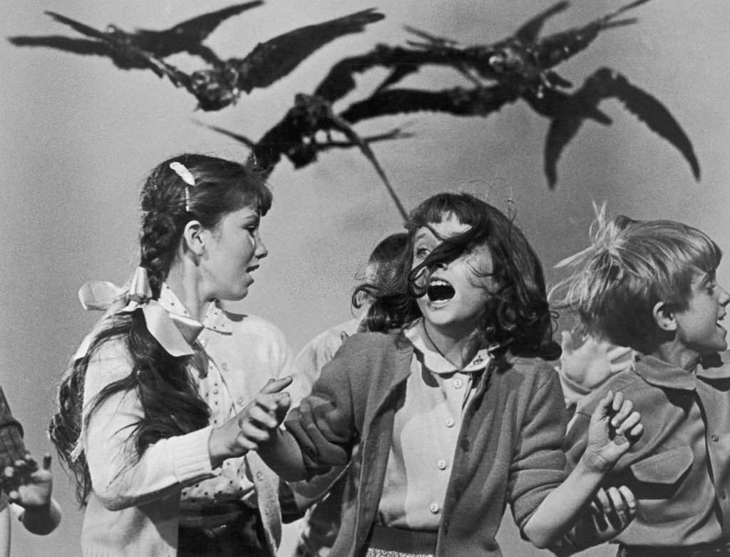 A group of schoolchildren flail about in terror at the avian attack in a publicity still for 'The Birds', 1963