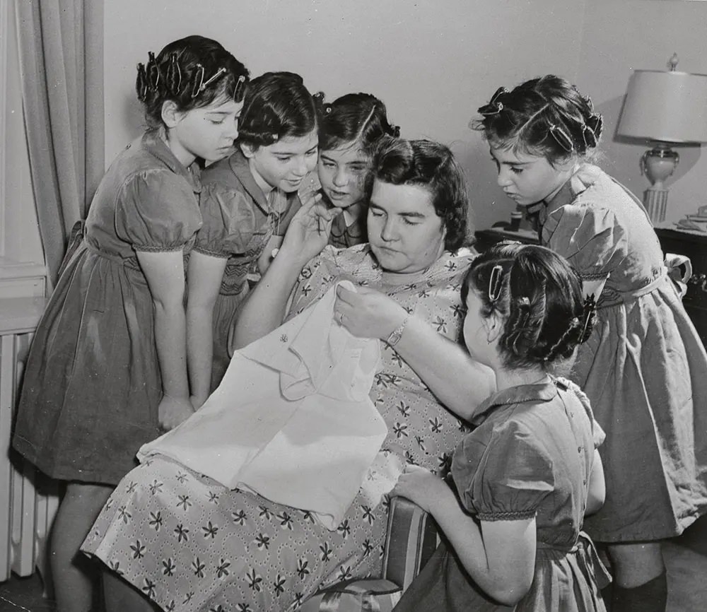 The sisters watch their mother sewing, 1943.