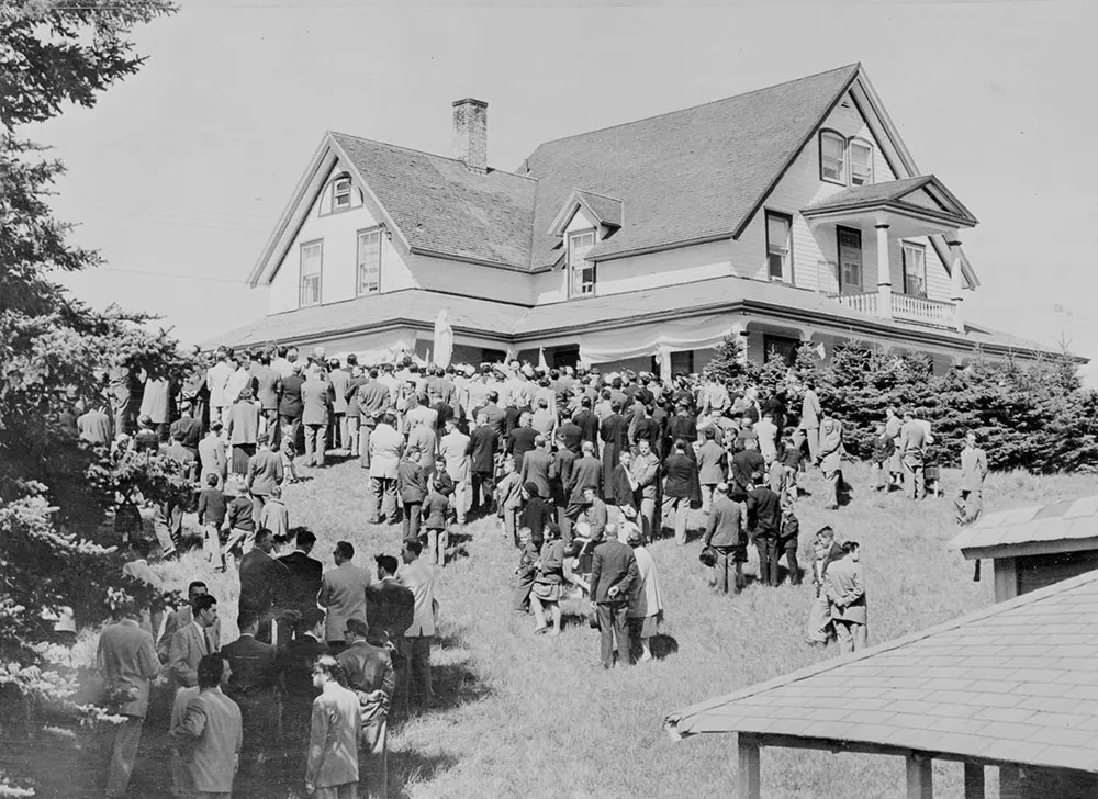 A crowd gathers around the Dionne home after the death of quintuplet Emilie, 1954.