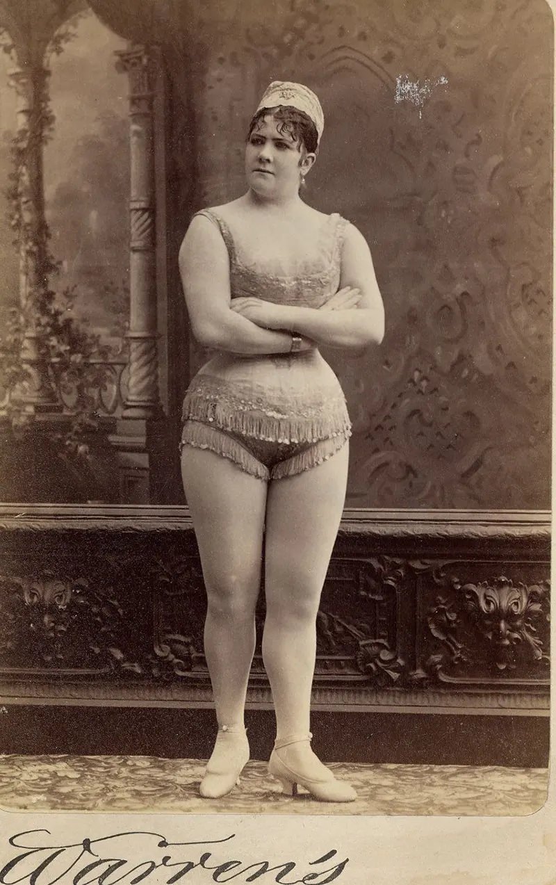 Viola Clifton facing front in a sleeveless, short, fringed top and short, fringed trunks.