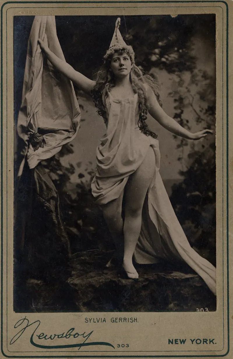 Sylvia Gerrish with draped dress and pointed hat in the woods.