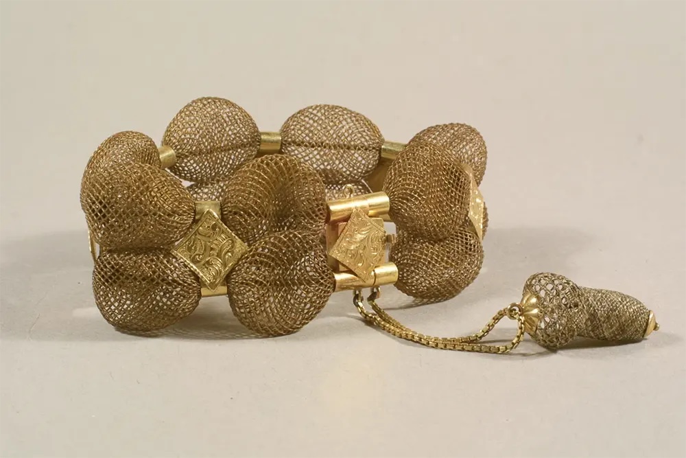 A bracelet made of brown table-worked hair with gold diamond findings.