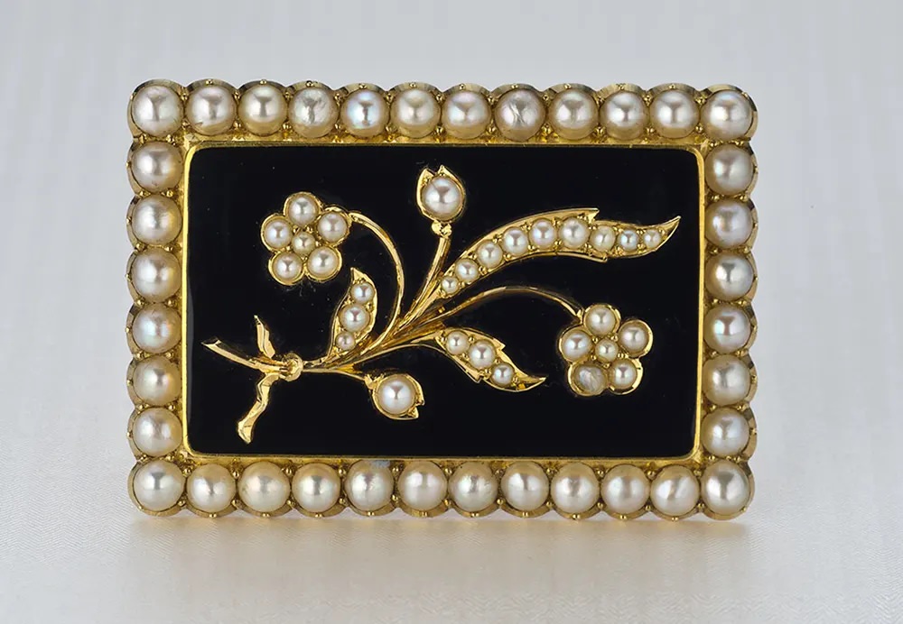 A pearl and black chalcedony Victorian mourning pin with a floral motif reflects a gentler view of death.