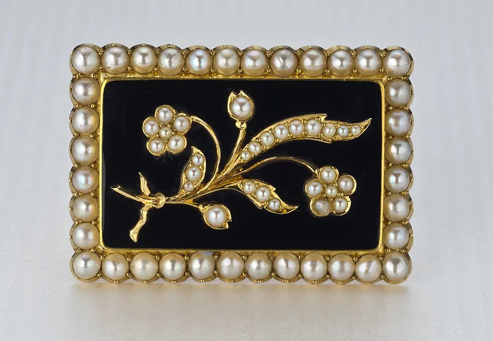 A pearl and black chalcedony Victorian mourning pin with a floral motif reflects a gentler view of death.