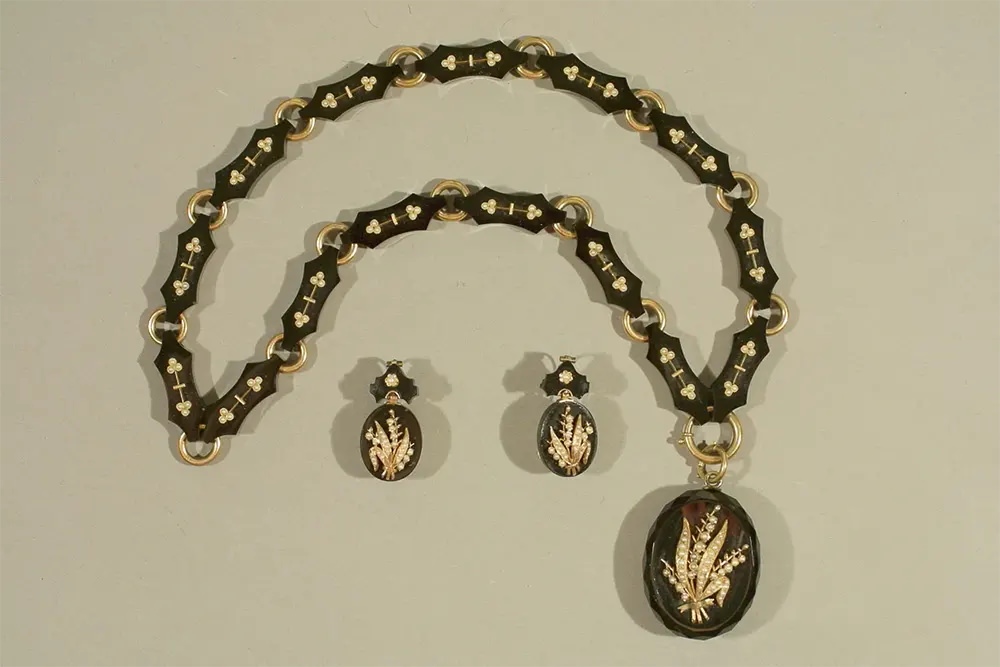 A set of onyx jewelry with gold and pearl depictions of sheaves of wheat.