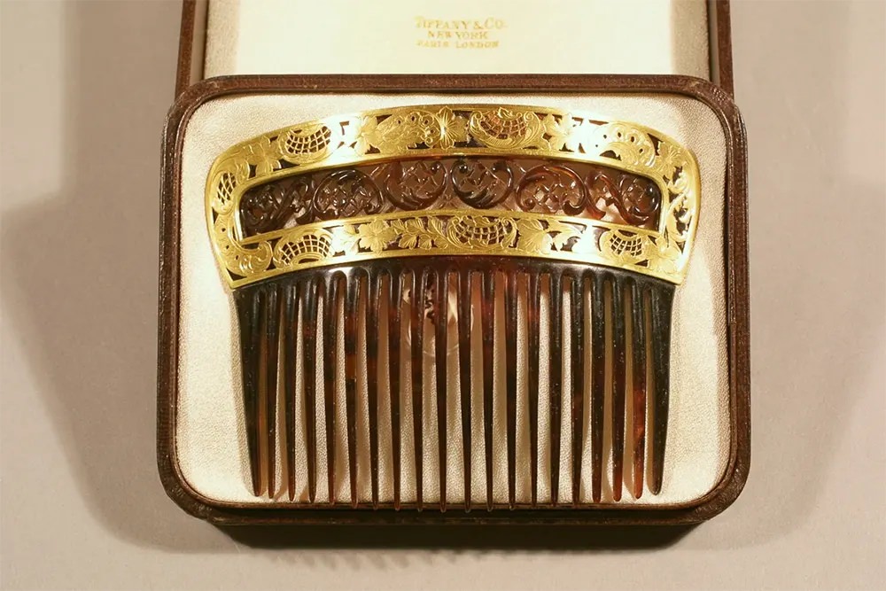 A tortoiseshell comb with a gold foliate scroll design.