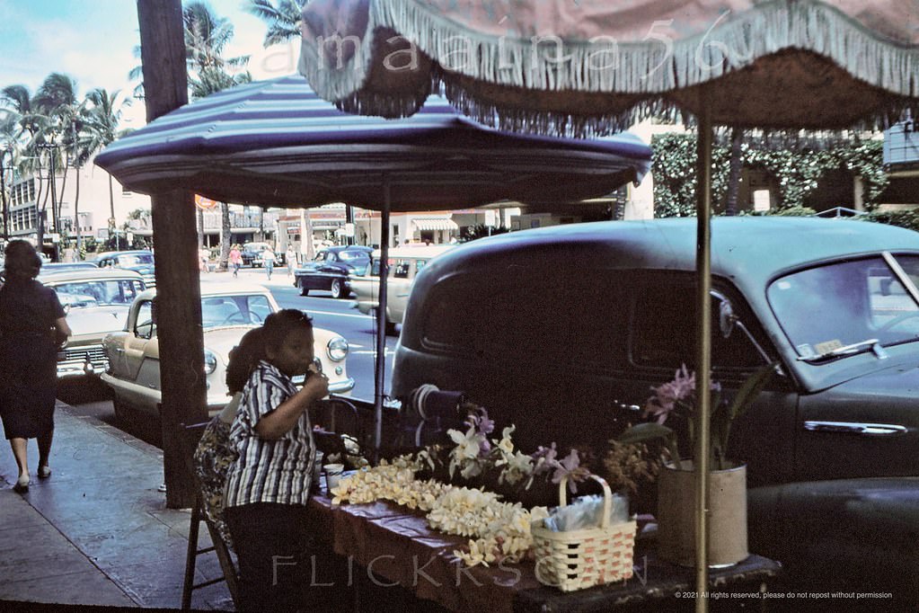 Lei seller on the sidewalk of Waikiki’s Kalakaua Avenue in front of the Royal Hawaiian Hotel, 1959