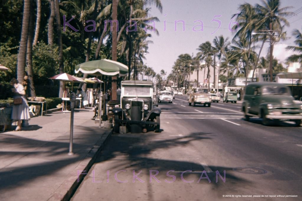 Waikiki’s Kalakaua Avenue at the sidewalk sellers in front of the grounds of the Royal Hawaiian Hotel, 1958