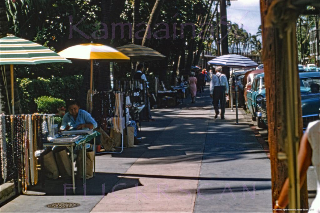 The gauntlet of Hawaiian jewellery, crafts, and lei sellers on the Kalakaua Avenue sidewalk in front of Waikiki’s Royal Hawaiian Hotel, 1958
