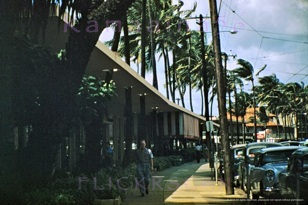 Late afternoon looking Ewa (more or less northwest here) along the makai side of Kalakaua Avenue in front of McInerny's towards Lewers in Waikiki, 1956