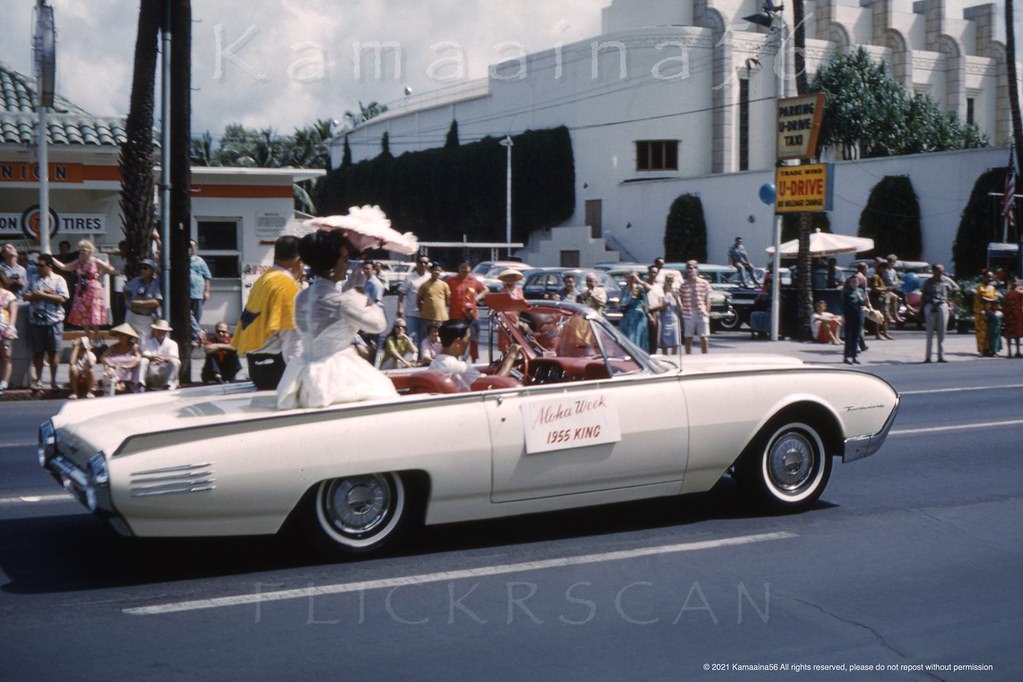 Aloha Week parade on Kalakaua Avenue just east of Seaside Avenue with a couple of old Waikiki buildings still standing in the background, 1961