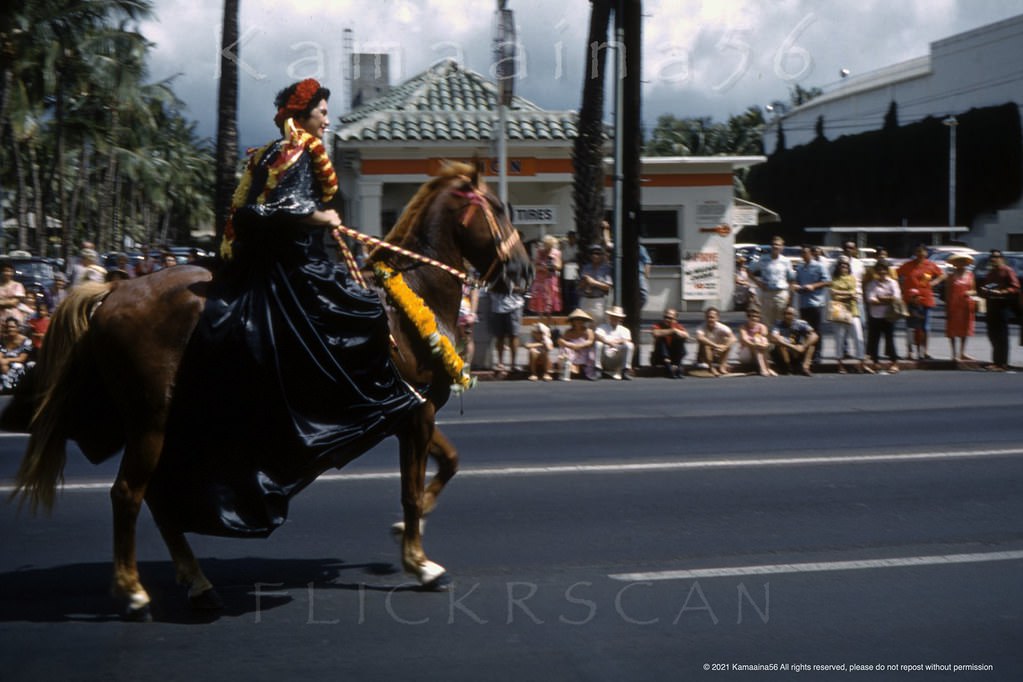 Pa’u Rider in the Aloha Week parade in Waikiki passing by long-time Union 76 gas station on the corner of Kalakaua Avenue at Seaside, 1961