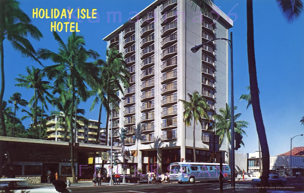Street level view of the 14 floor Holiday Isle Hotel on the makai side of Kalakaua Avenue at Lewers Street, 1960