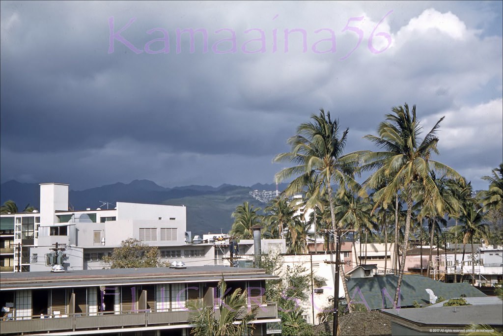 Looking inland across the Waikiki cityscape towards the clouds over the Koolau Mountains, 1960