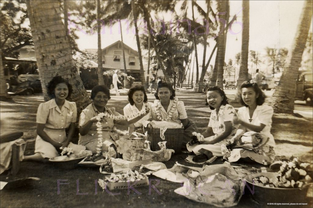Lei stringers at the park on the makai side of Kalakaua Avenue at Beachwalk, 1940s