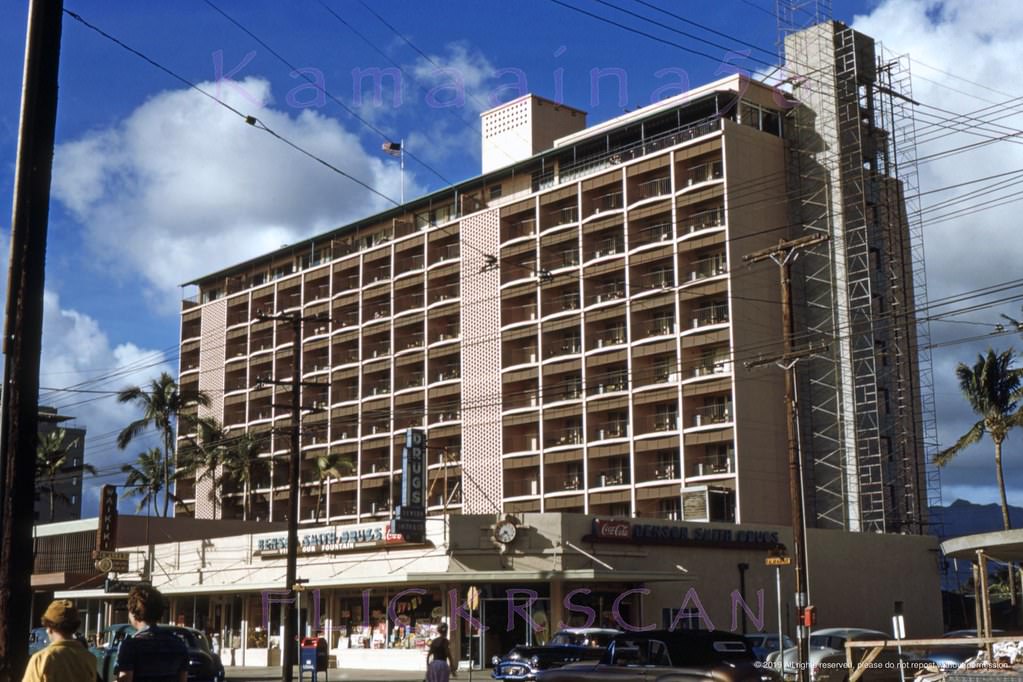 The old Benson Smith Drugstore in front of the 10 floor Waikiki Biltmore Hotel finishing up construction on the mauka (inland) side of Kalakaua Avenue at Uluniu Avenue, 1954.