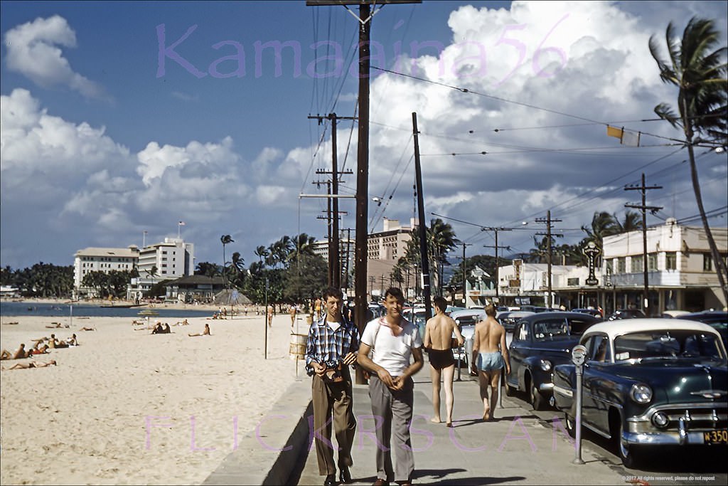 Street level snap of Waikiki’s Kalakaua Avenue looking west back when there was still two-way traffic and on-street metered parking, 1956