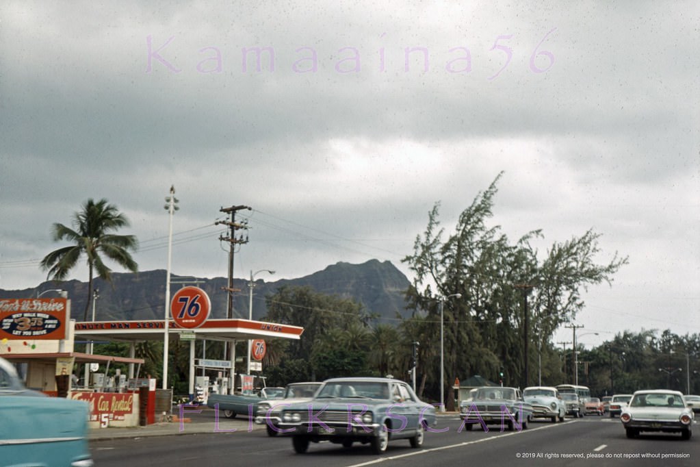 Waikiki’s busy Kalakaua Avenue at the corner of Kapahulu Avenue with Diamond Head Crater in the background, 1965