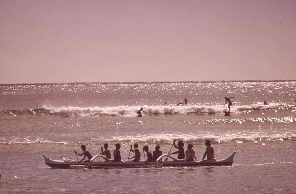 Outrigger canoes and surfers at Waikiki Beach, Honolulu, 1973