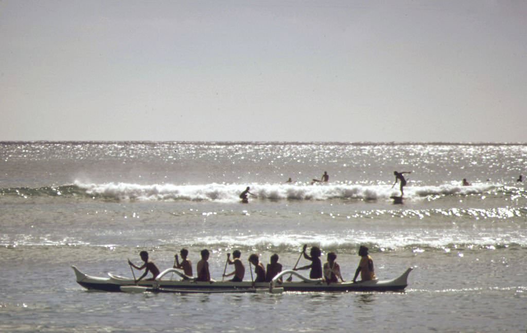 Outrigger canoes and surfers at Waikiki Beach, October 1973