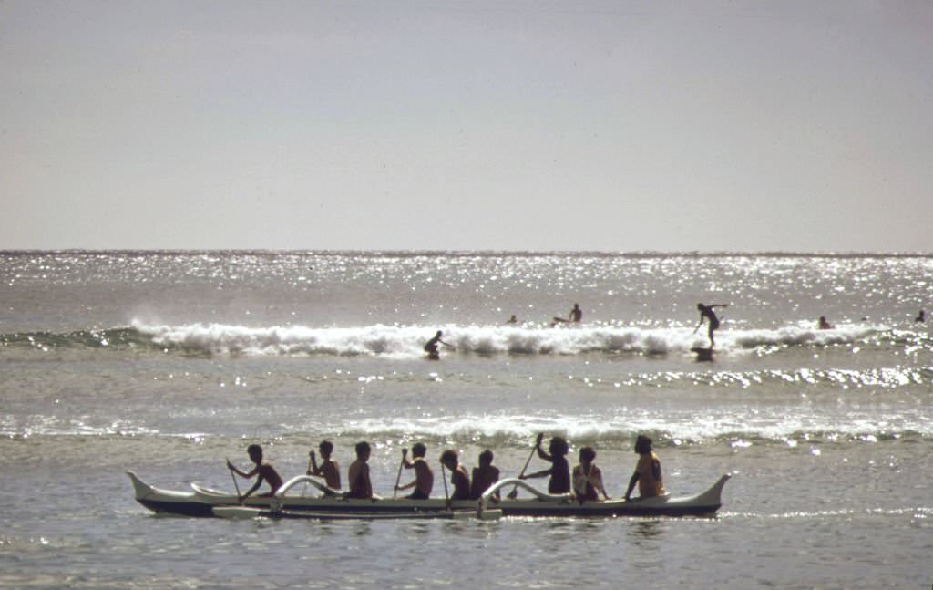Outrigger canoes and surfers at Waikiki Beach, October 1973