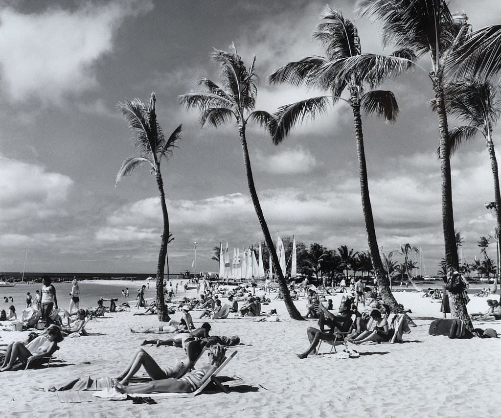 A packed beach with people sunbathing and enjoying the sea, 1970