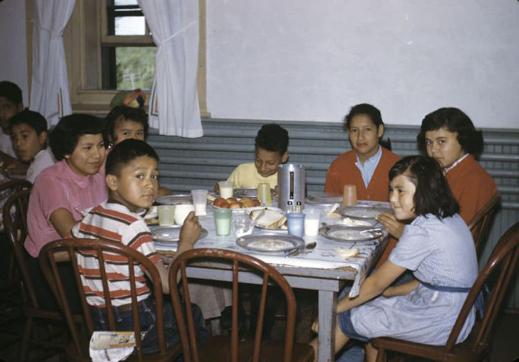 Children at mealtime, with teacher Angeline Hopinka, Bethany Indian Mission, Wittenberg, Wisconsin, . 1953