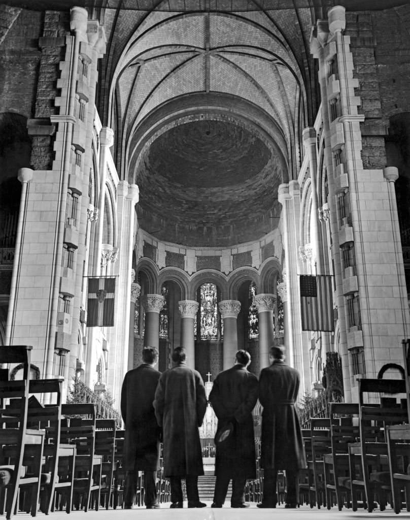 Four visitors look across the nave toward the unfinished sanctuary and choir at the Cathedral of St John the Divine, New York World's Fair, 1938