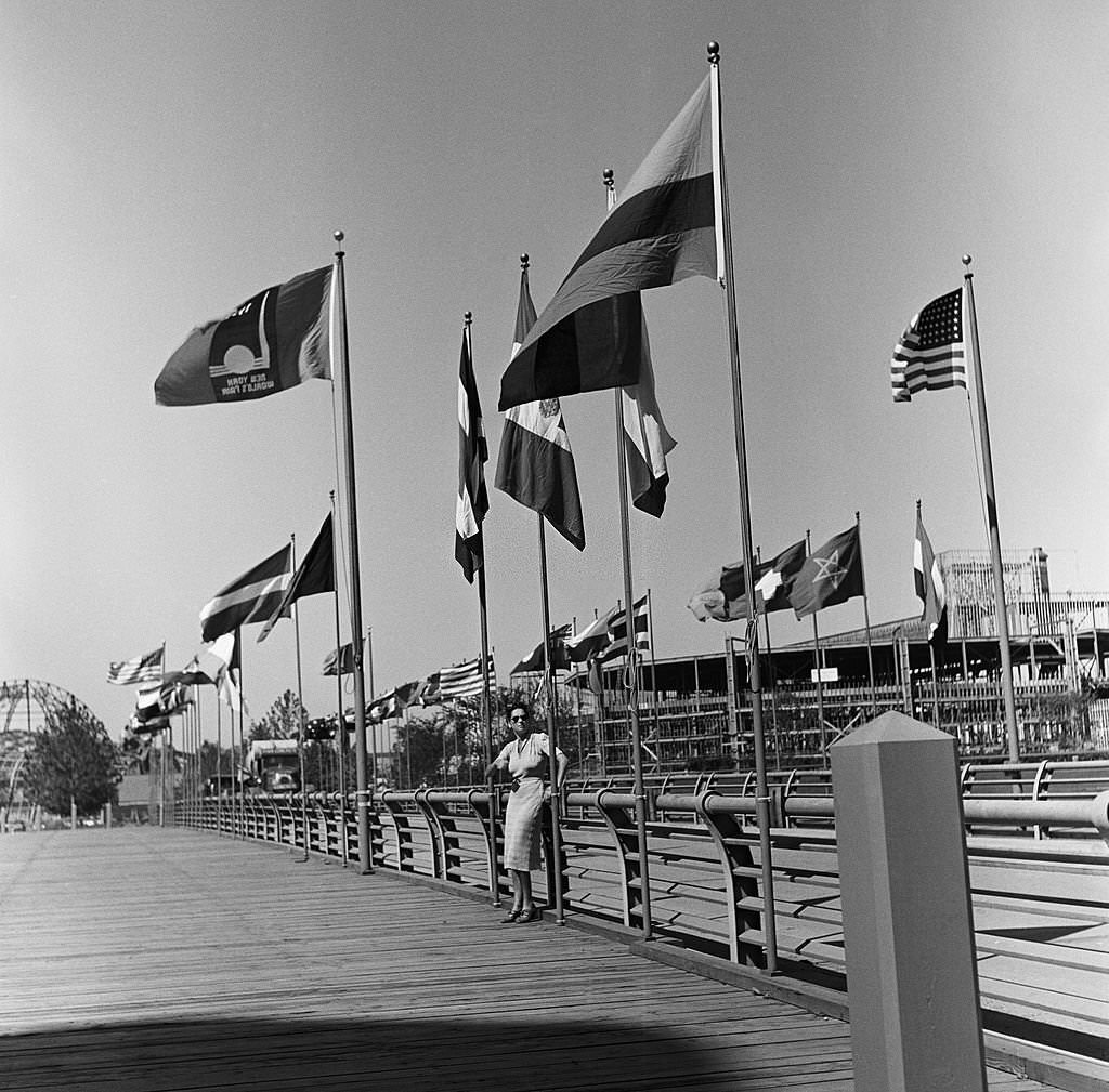 A woman stands under a sea of flags during the construction of the 1939 New York World's Fair in Flushing Meadows, Queens in the summer of 1938 in New York City.