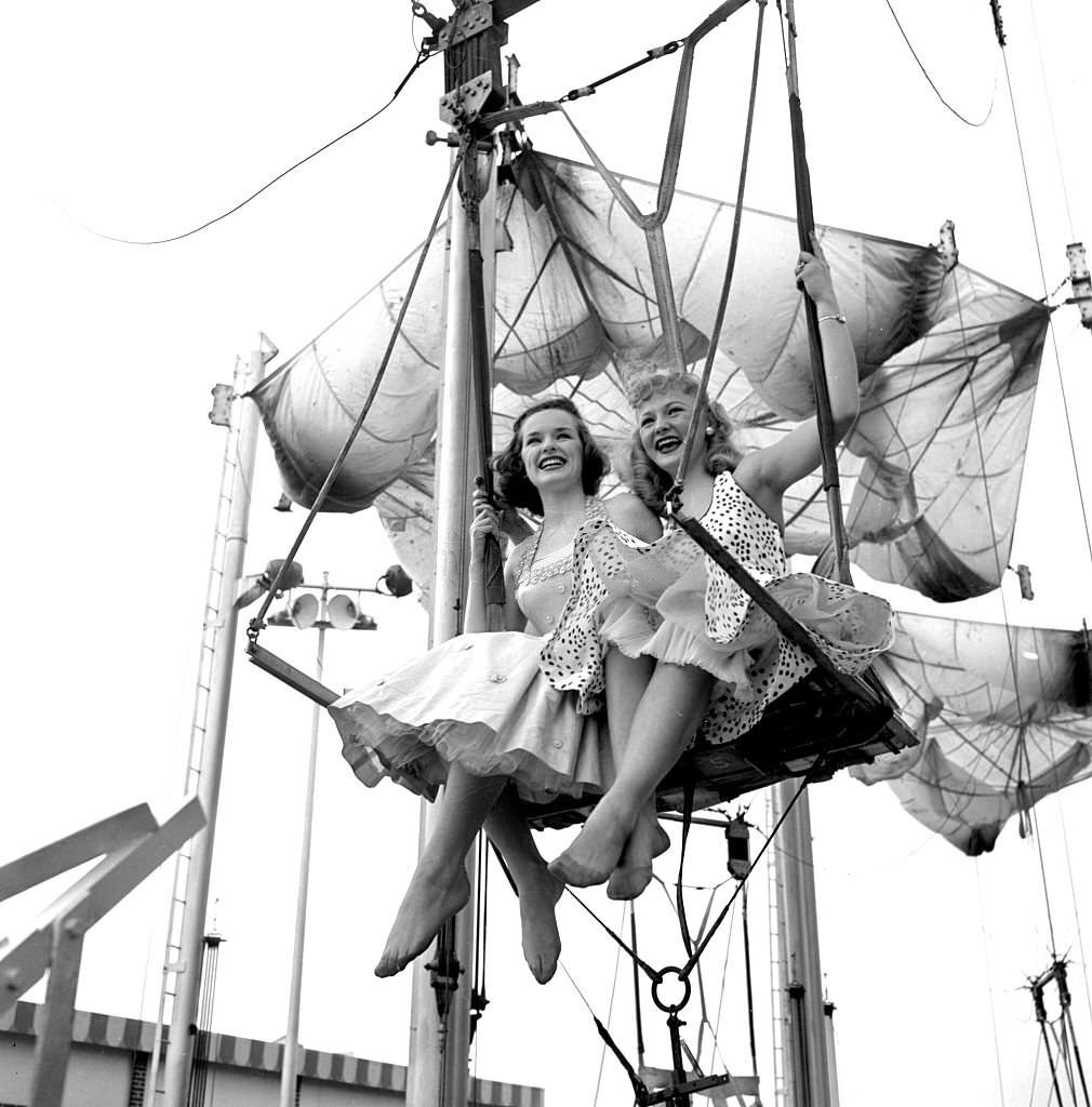 Models from the CBS gameshow, "The Big Payoff," Pat Conway and Connie Mavis ride The Parachute Jump, originally built for the 1939 World's Fair, at Steeplechase Park.