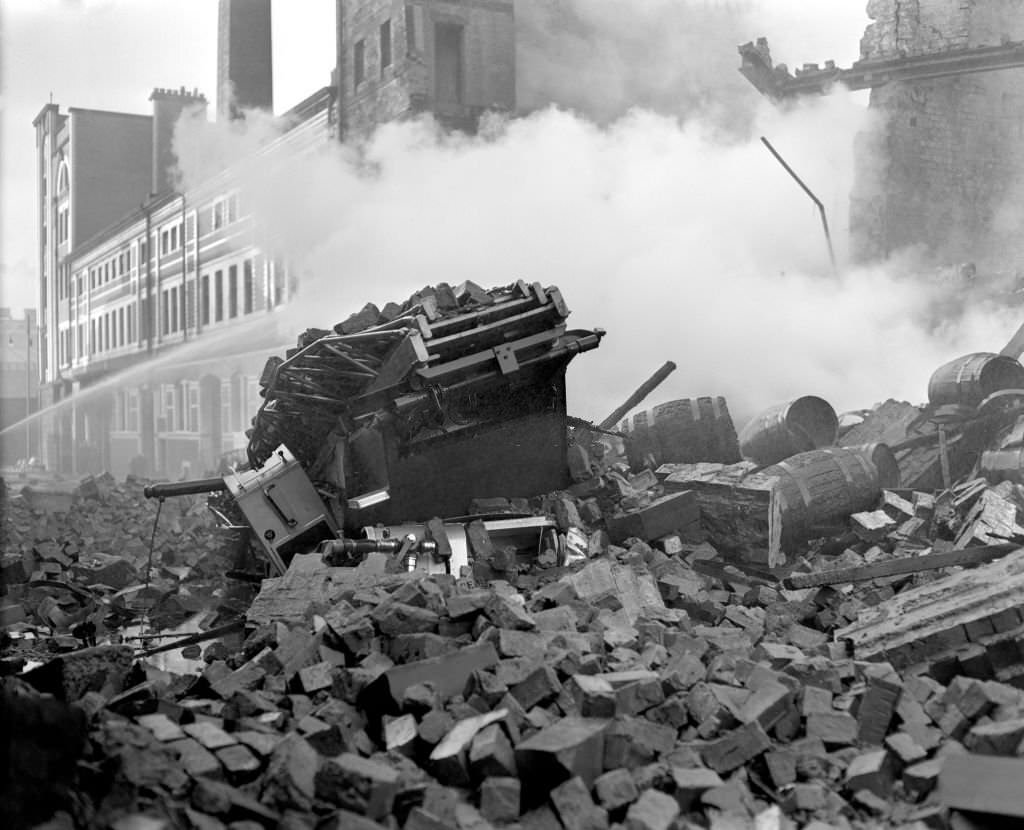 Cheapside Street Whisky Bond Fire. Tons of rubble and whisky barrels engulf a fire engine, on the morning after a disastrous Glasgow whisky warehouse blaze, 1960s