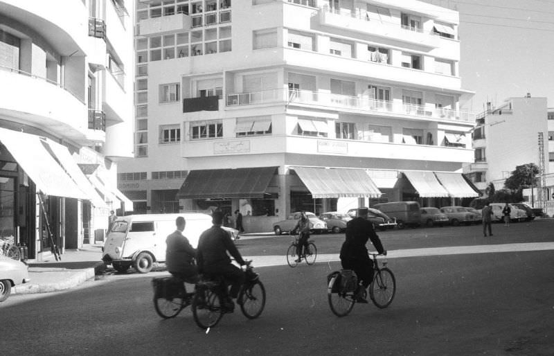 People bicycling past modern buildings in Rabat, 1960s