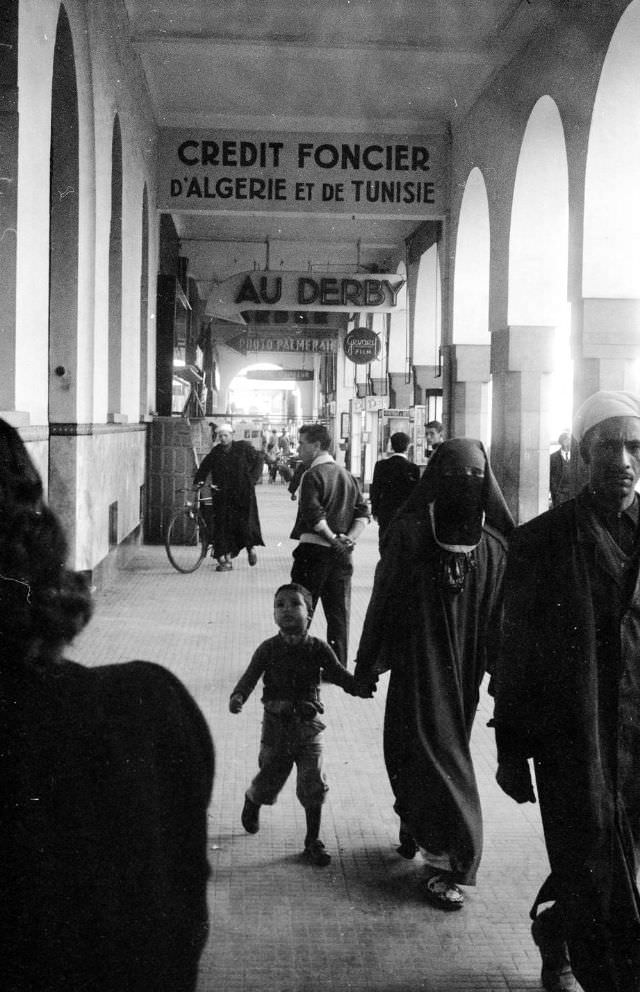 Pedestrians walking past stores in Rabat, 1960s