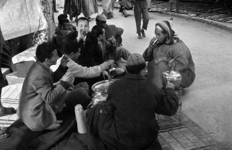 Seated men drinking tea at souk in Marrakech, 1960s
