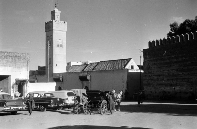 Horse-drawn carriage parked next to automobiles in Fez, 1960s