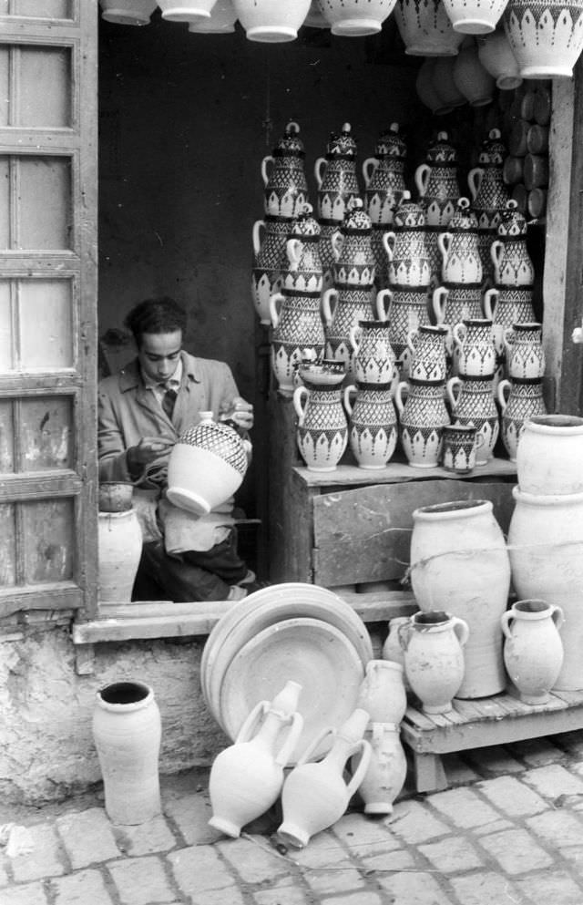 Man finger-painting vases in Rabat pottery shop, 1960s