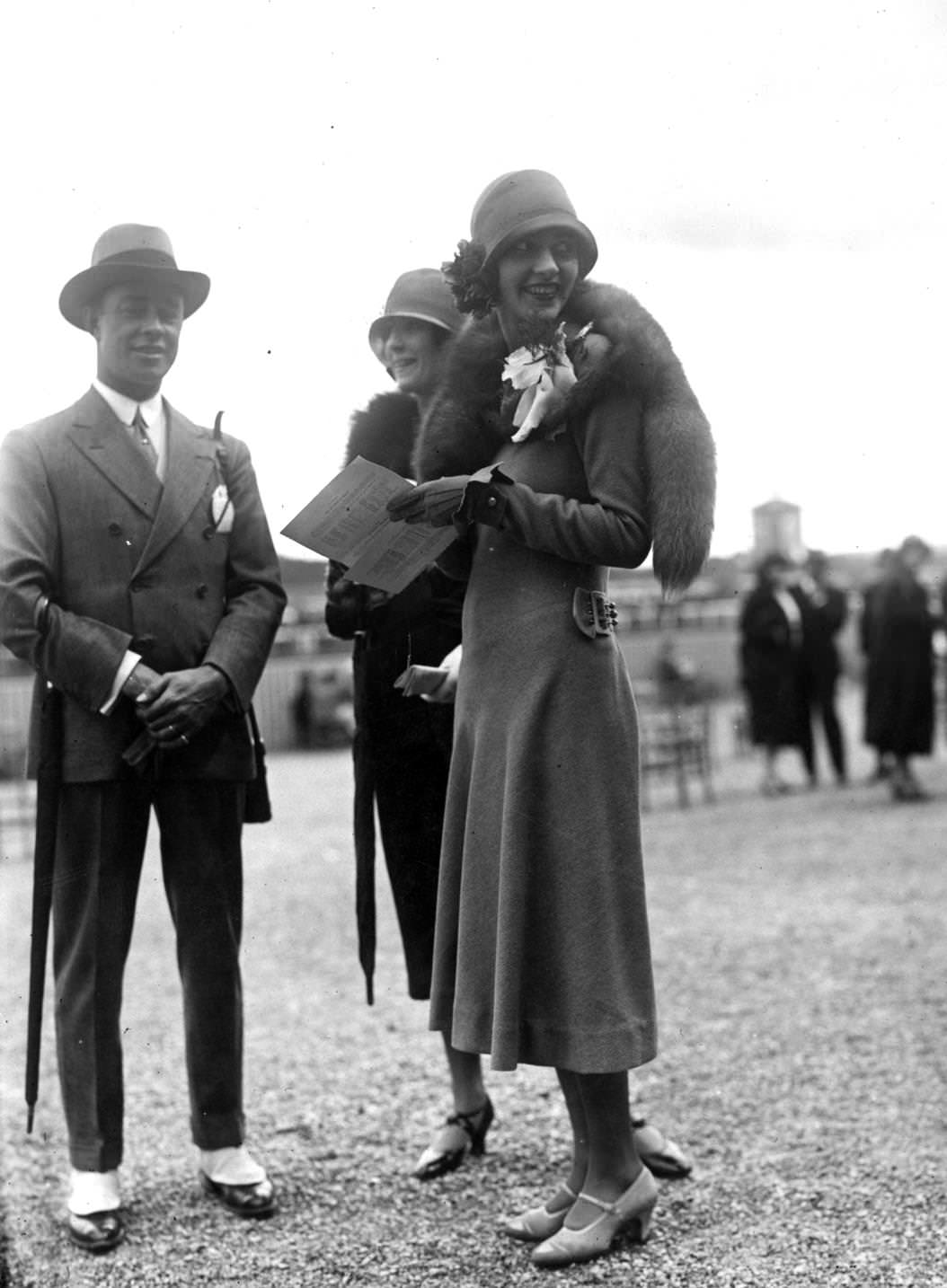 An elegant outfit designed by Lenief. A slim dress has a half-belt back at the back and long sleeves. It is worn with a cloche hat, fox furs and one-bar shoes, 1925