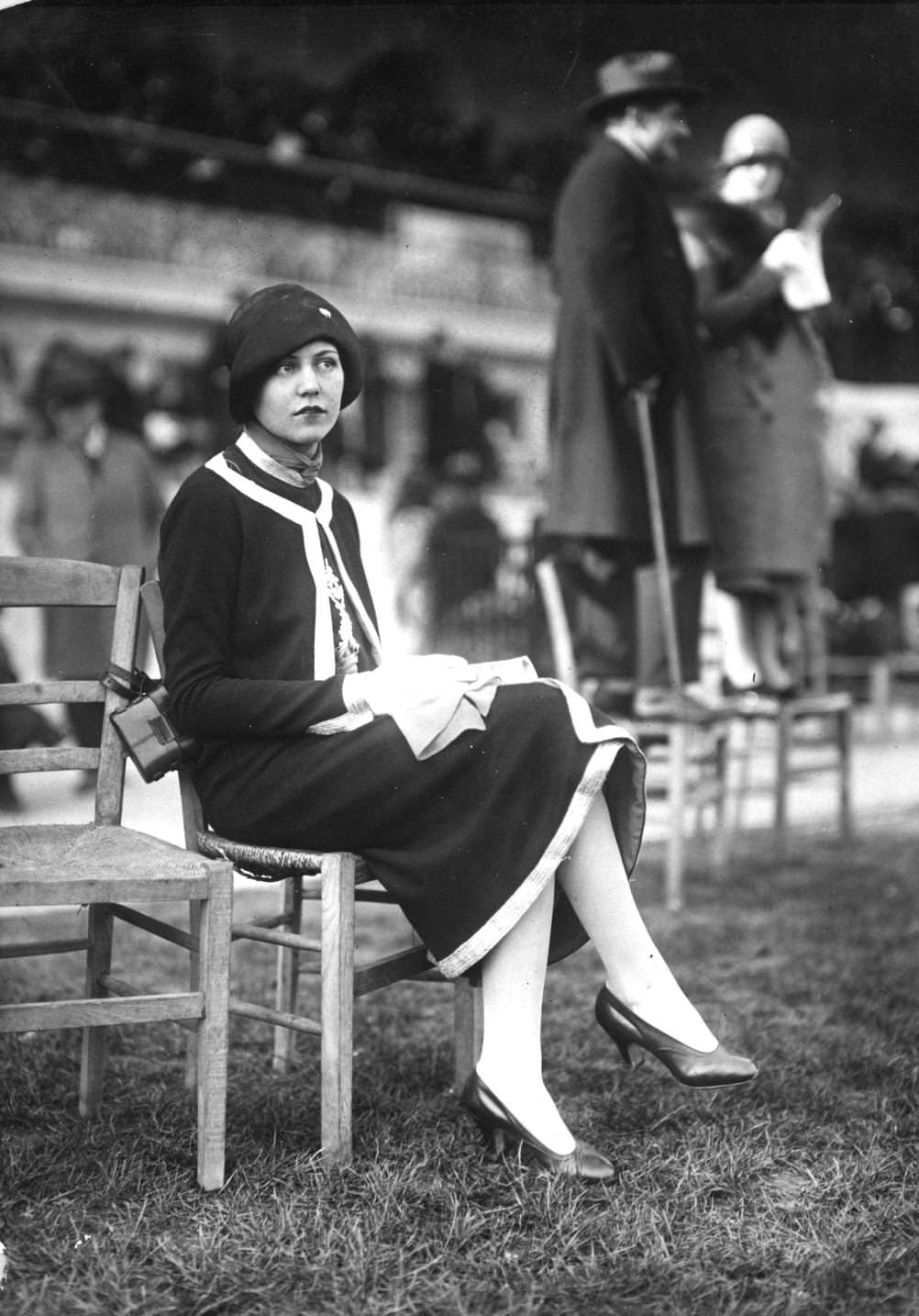 Jumper suit with contrasting trim worn with a cloche hat with turned back brim, 1925