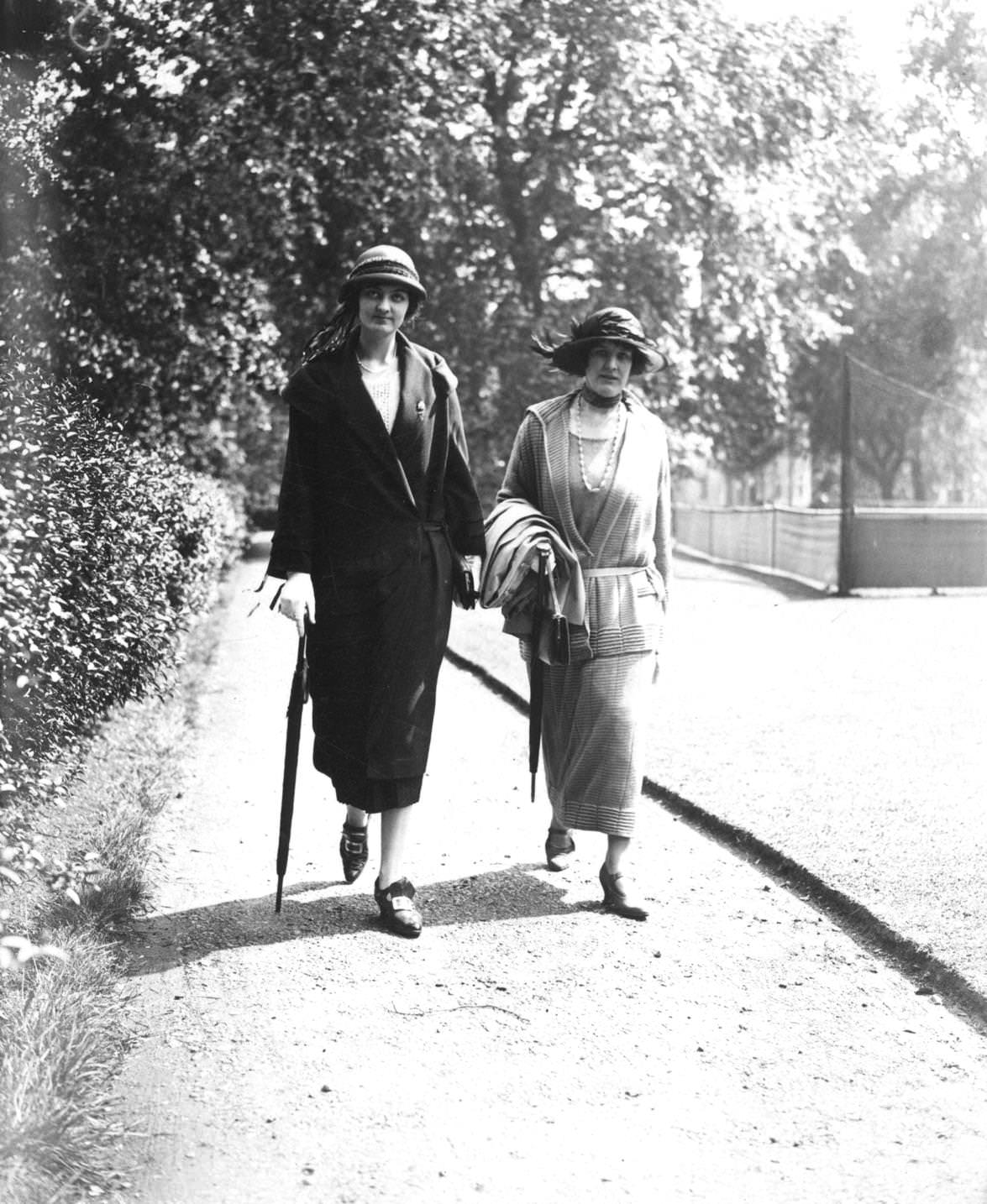Two formally dressed women walking through Regent's Park, London on their way to Lady Beatty's tennis and garden party at Hanover Lodge in the park, 1924