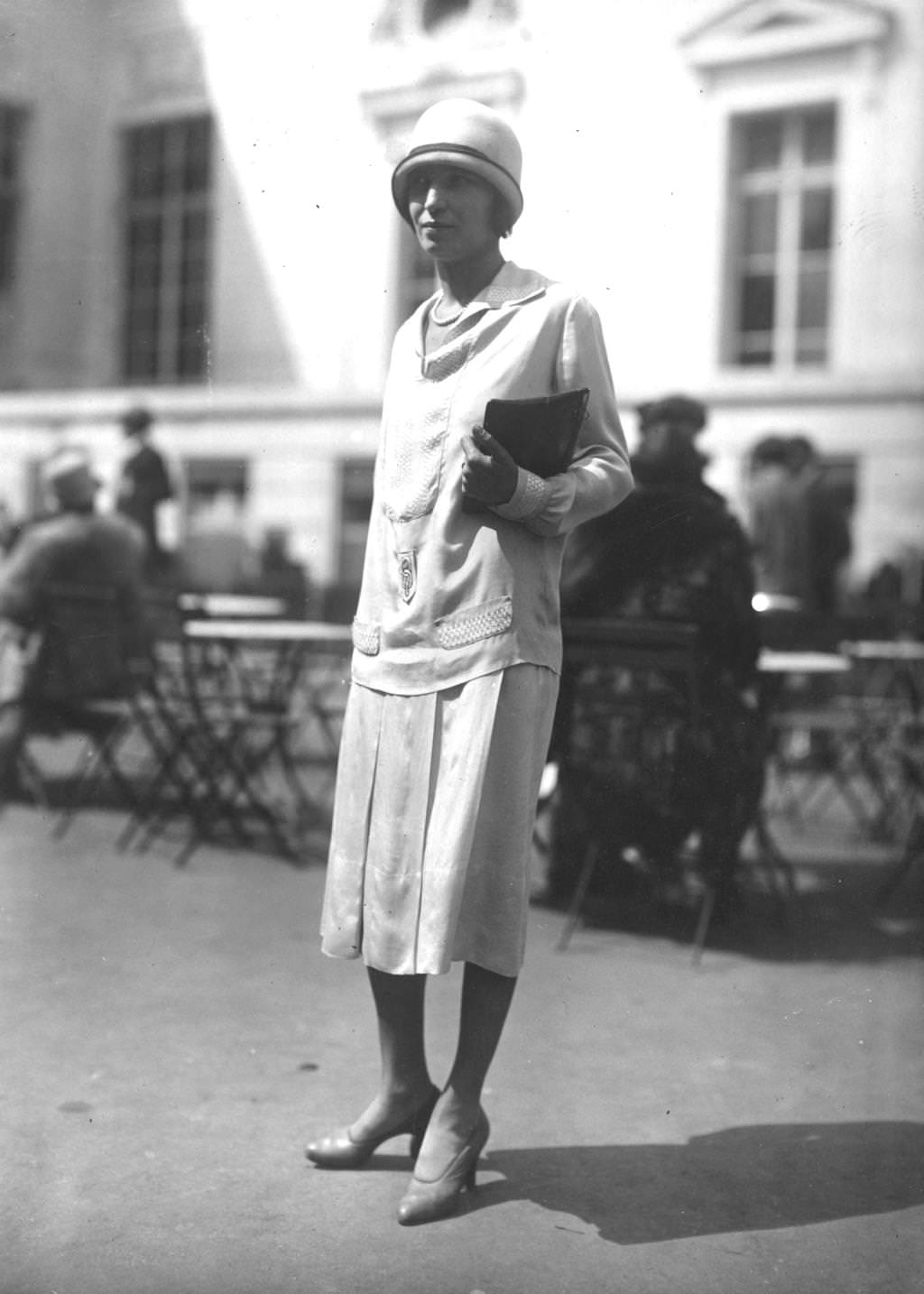 A model wearing a silk day dress with a traditional cloche hat, 1925