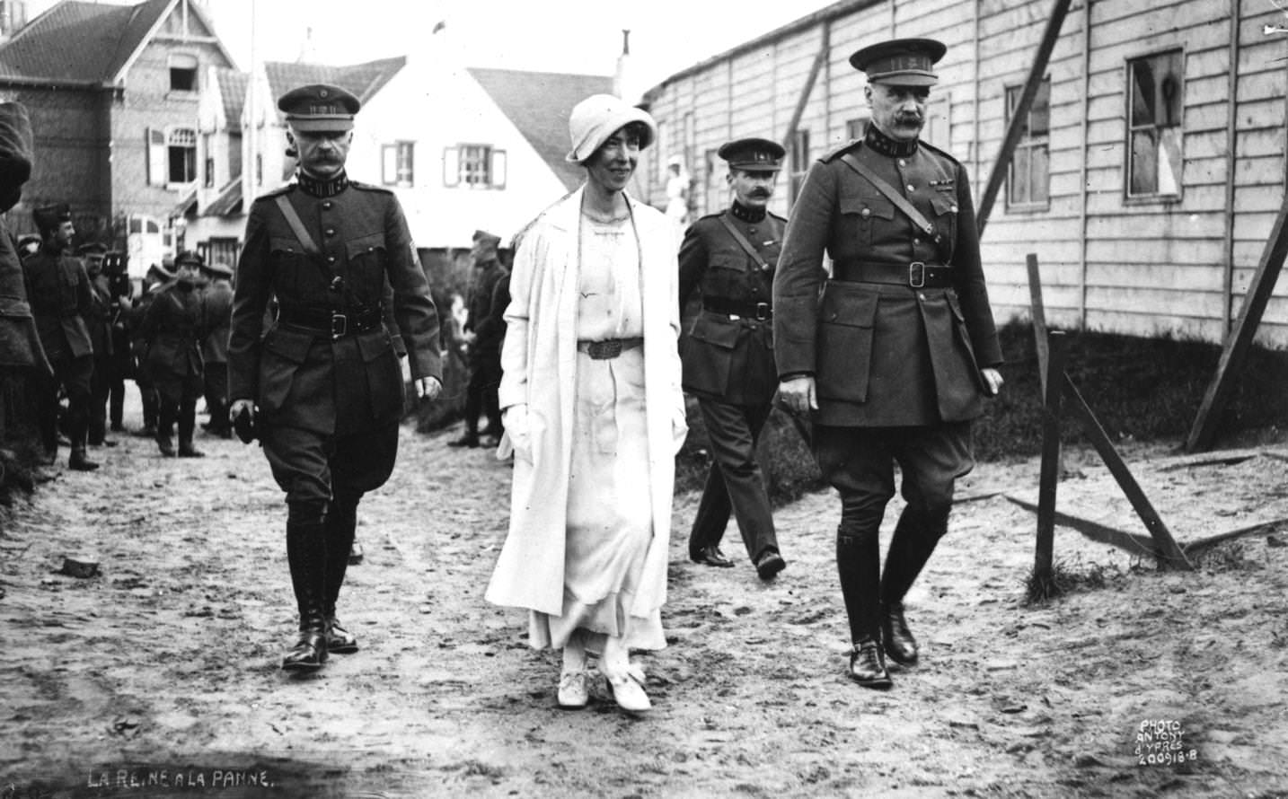 Elizabeth, Queen of the Belgians (1876 - 1965) in cloche hat, wife of King Albert, accompanied by soldiers, 1920