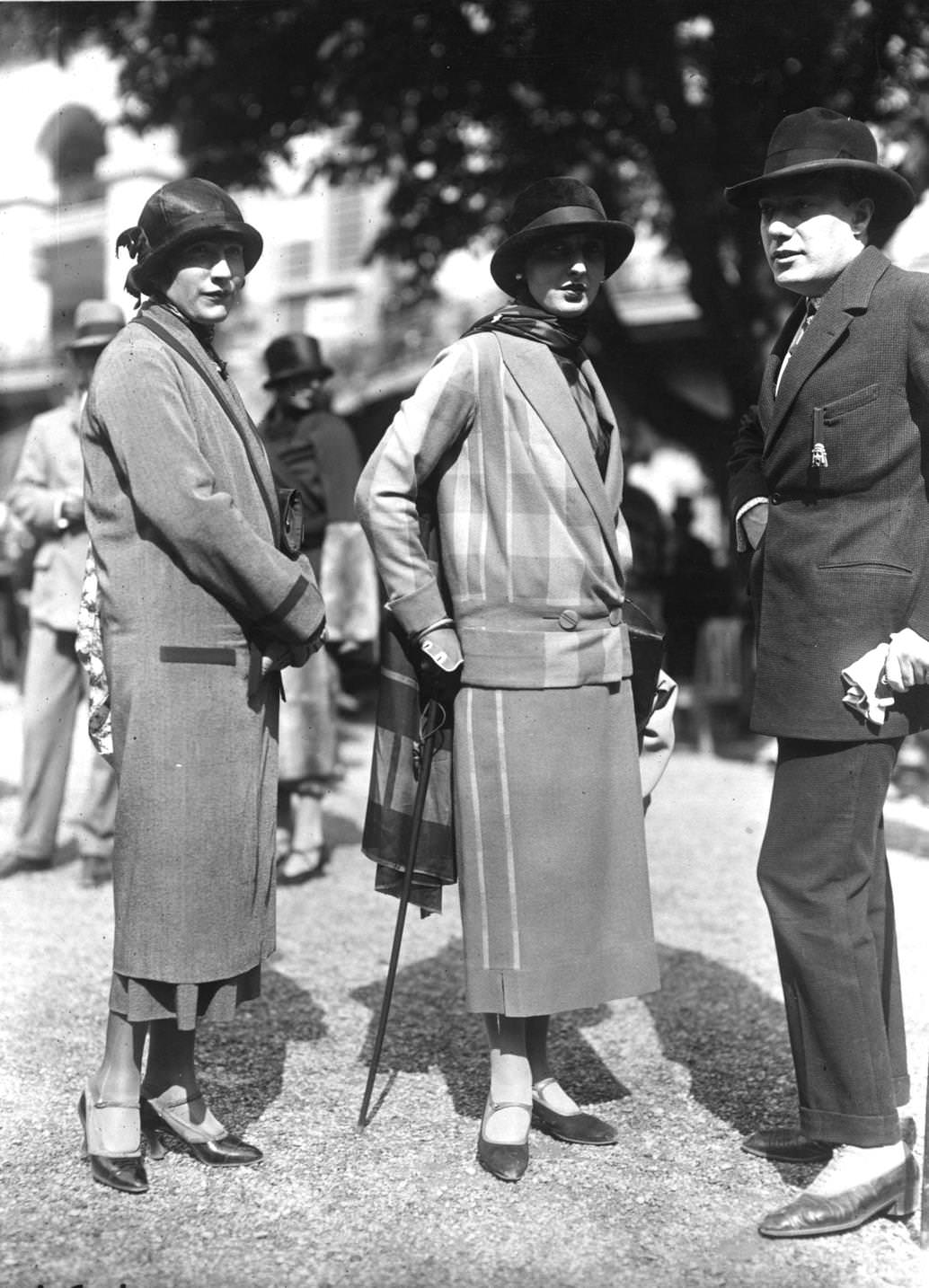 A seven-eights straight coat with a small brimmed cloche hat and a suit with waist length v-necked jacket and long scarf, 1924