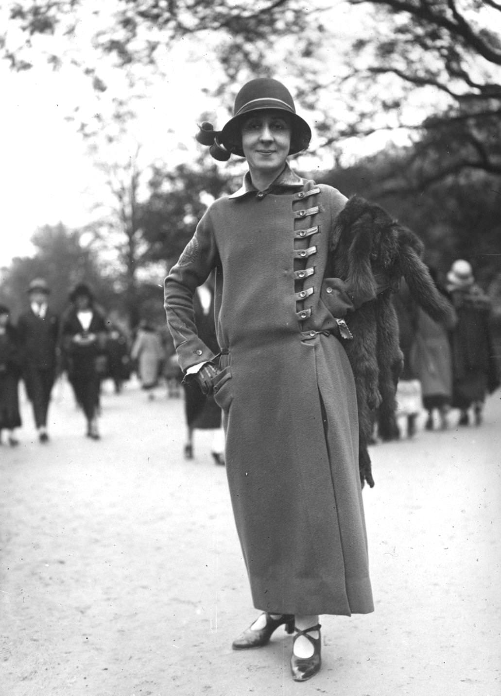 An ankle length coat designed by Jean Patou, buttoning at the side, with a leather collar and leather trim, 1923