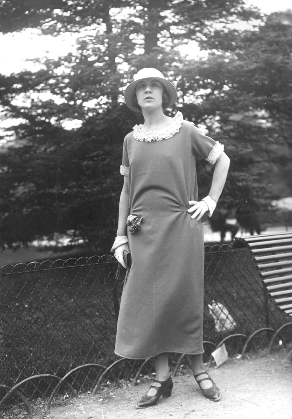 A model wearing a dress with a lace lined collar and cuffs and a pair of ornametal gloves, 1923