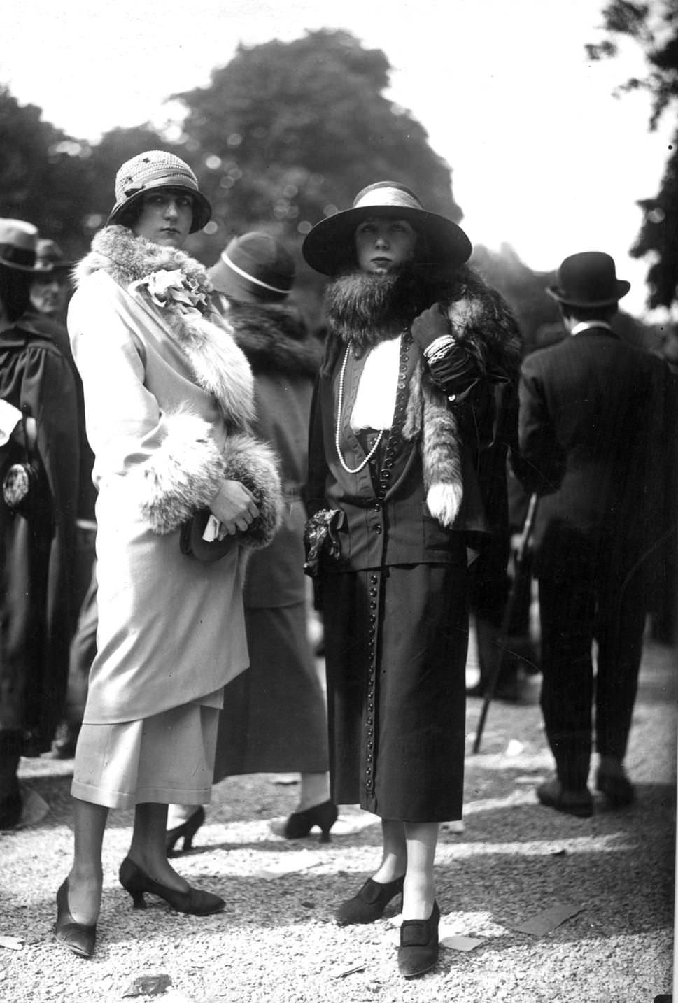 Dress and fur trimmed coat worn with a cloche hat and plain court shoes and a suit with front fasteninghigh waisted skirt, worn with a fox fur, a large-brimmed hat, 1923