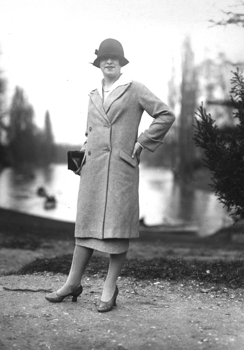 A model wearing a single breasted winter coat and a tailor made cloche hat designed in Paris, 1925
