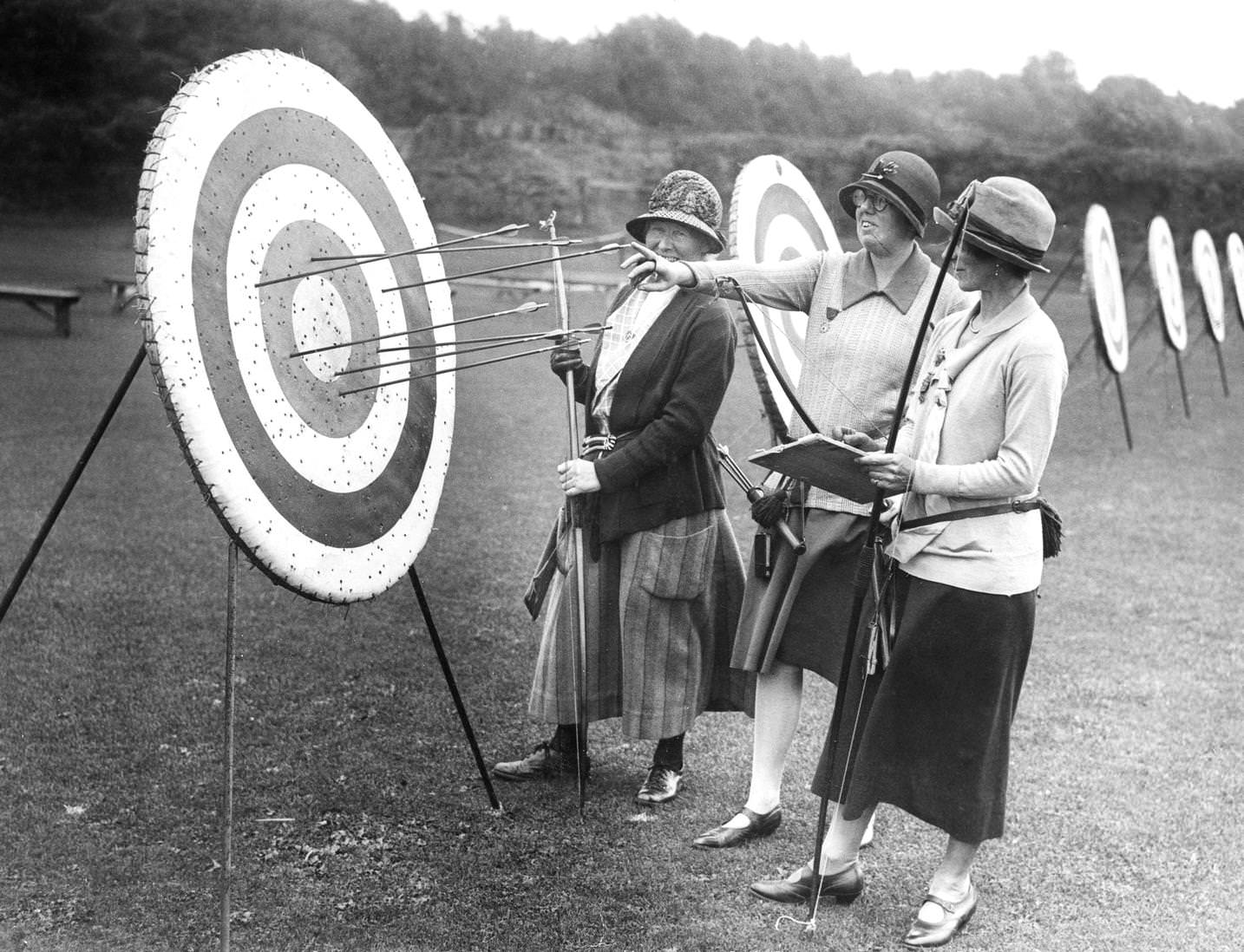 Female competitors checking their scores as they stand before a target during the Southern Counties Archery meeting, held at the Nevill Cricket Ground in Royal Tunbridge Wells, Kent, England, 1925